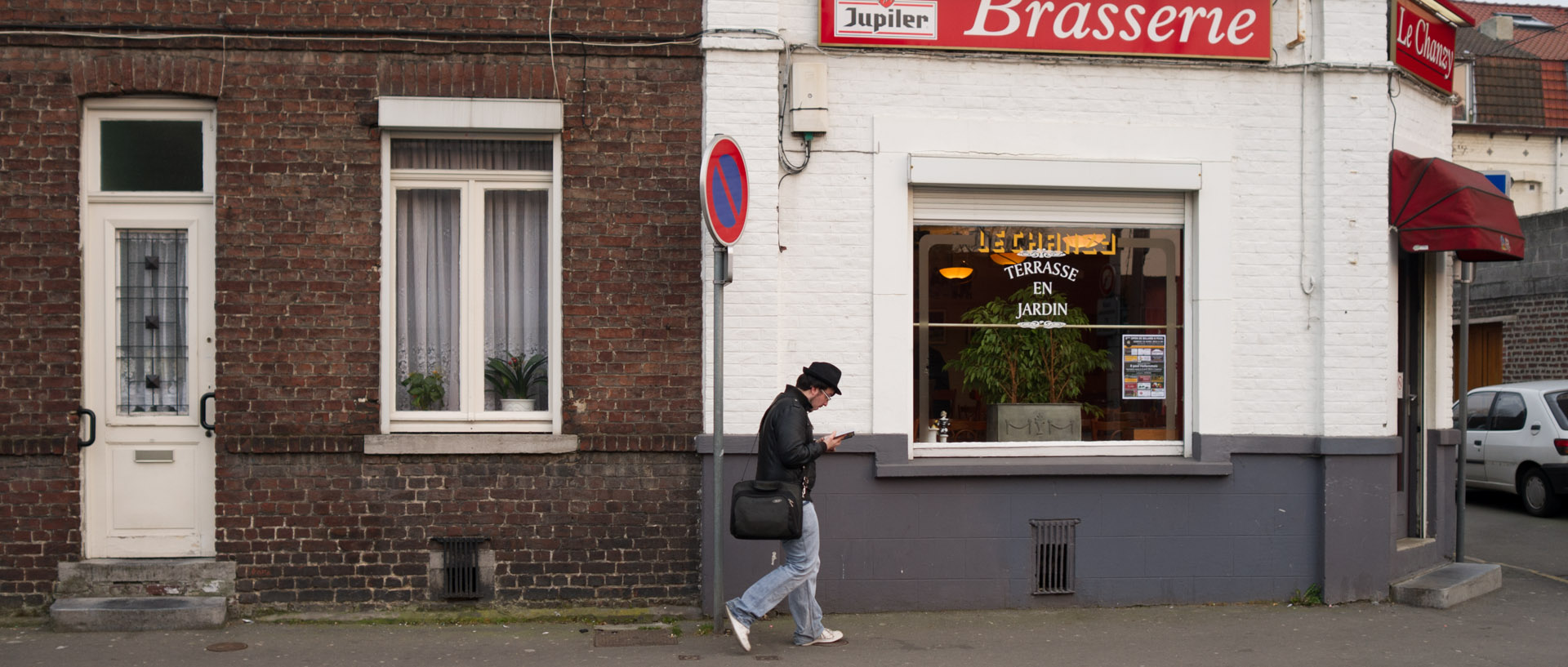Homme lisant un livre en marchant, rue Chanzy, à Hellemmes Lille.